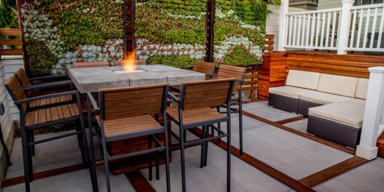 backyard sitting area with fire pit and green wall