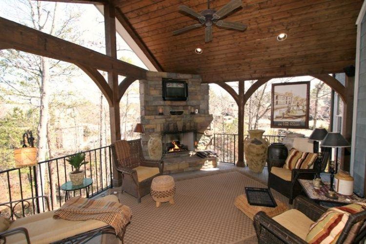 deck with stone fireplace and flat screen tv