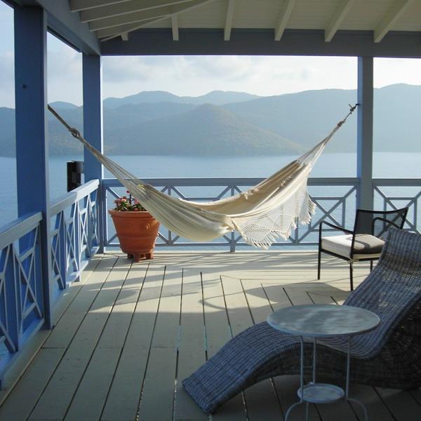 wooden deck overlooking water with hammock