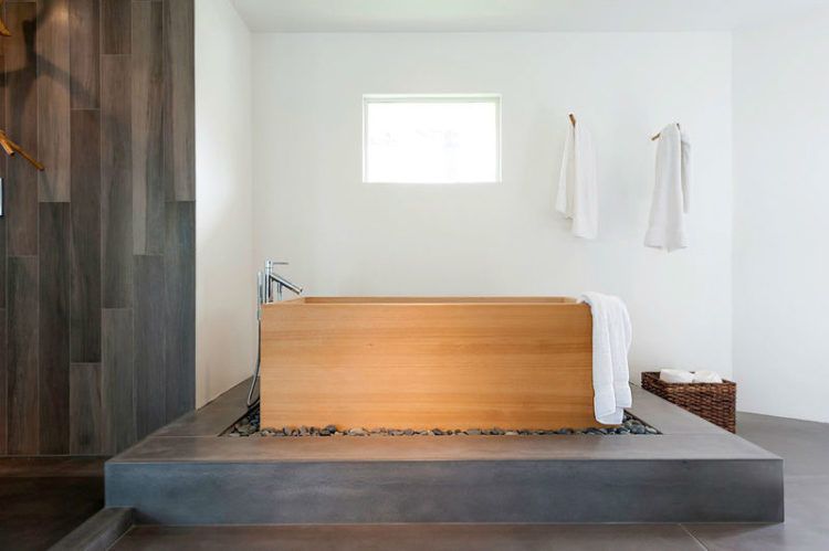 wooden freestanding bath tub on platform