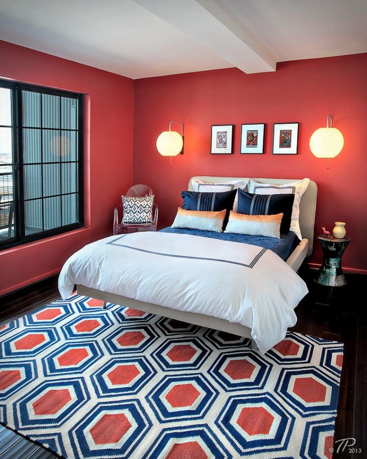 bedroom with red walls and geometric area rug