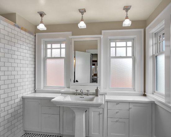 pedestal sink with cabinets behind