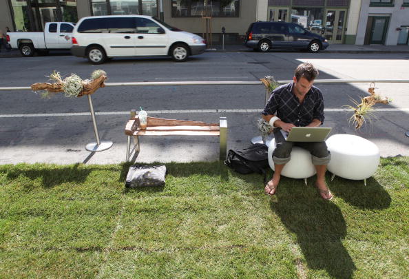 man sitting outside on a computer