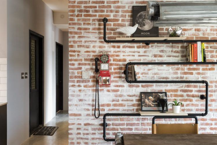 creative pipe shelving on brick wall