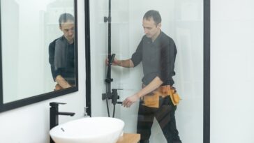 Plumber installing a shower cabin in bathroom