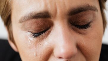 Tears on face of crop anonymous woman