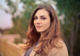 Closeup Photo of Woman With Brown Coat and Gray Top