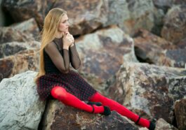 woman in black sleeveless dress sitting on gray rock