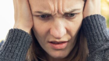 a man holding his head with both hands