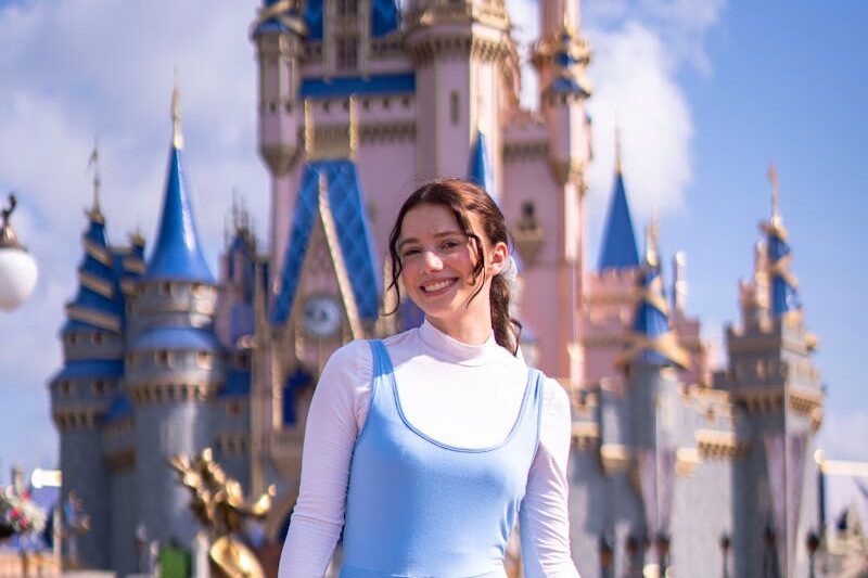 Smiling Girl in front of a Disney Castle
