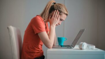 Young troubled woman using laptop at home