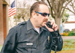 Man in Black Police Uniform Holding Black Radio