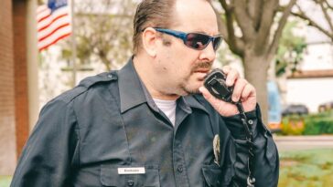 Man in Black Police Uniform Holding Black Radio