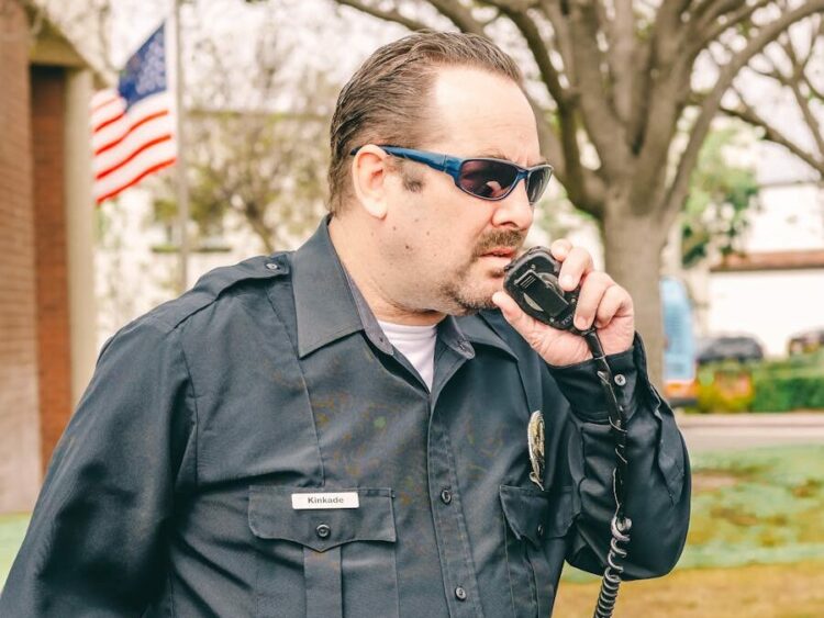 Man in Black Police Uniform Holding Black Radio