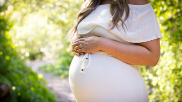 pregnant woman standing near green plants