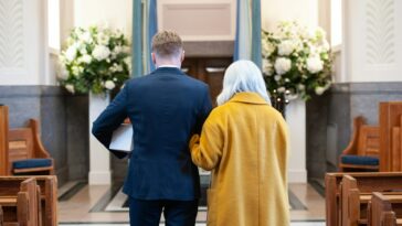 a man and a woman standing in front of a church