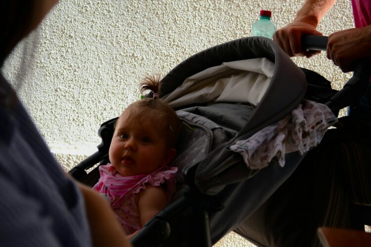 a baby in a stroller being pushed by a woman