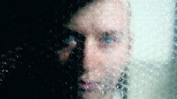 a woman looking through a window with bubbles on it