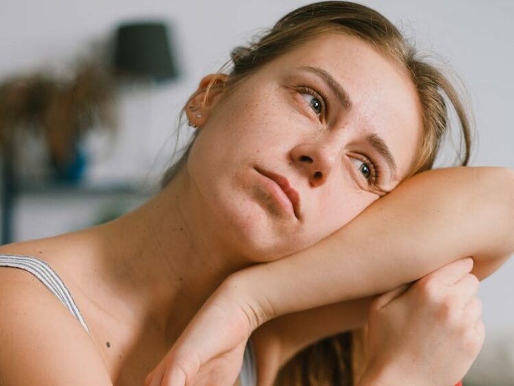 Tired housewife leaning on mop during housework