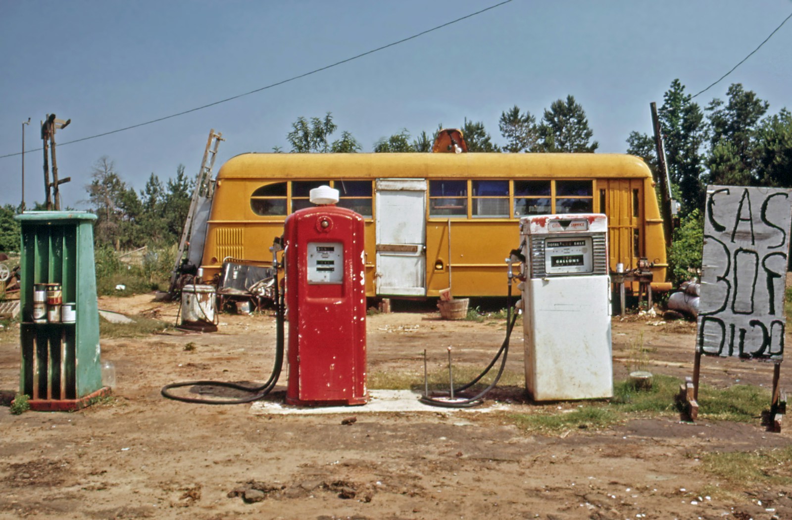 an old gas station with a yellow bus in the background
