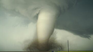 a large tornado is coming down the road