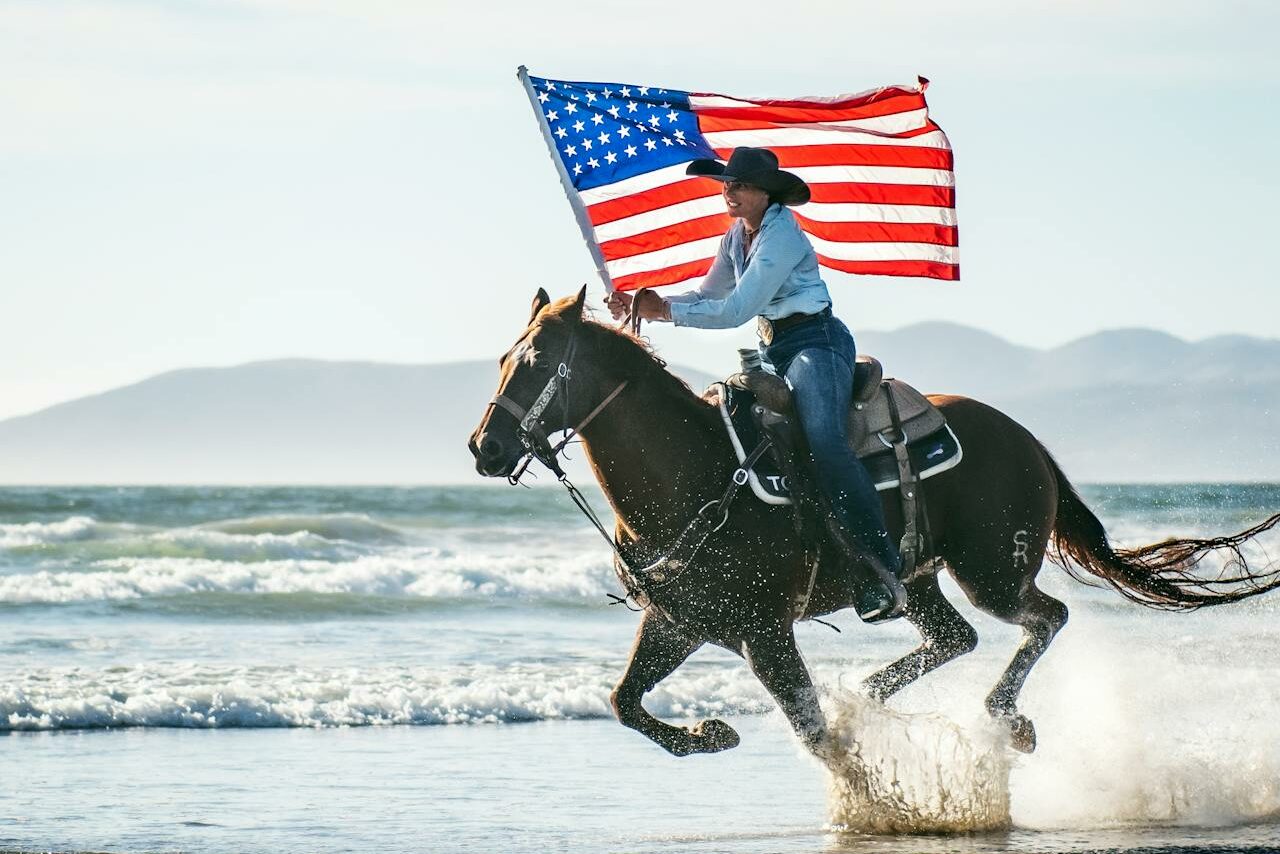 Woman Holding a Flag While Riding a Horse