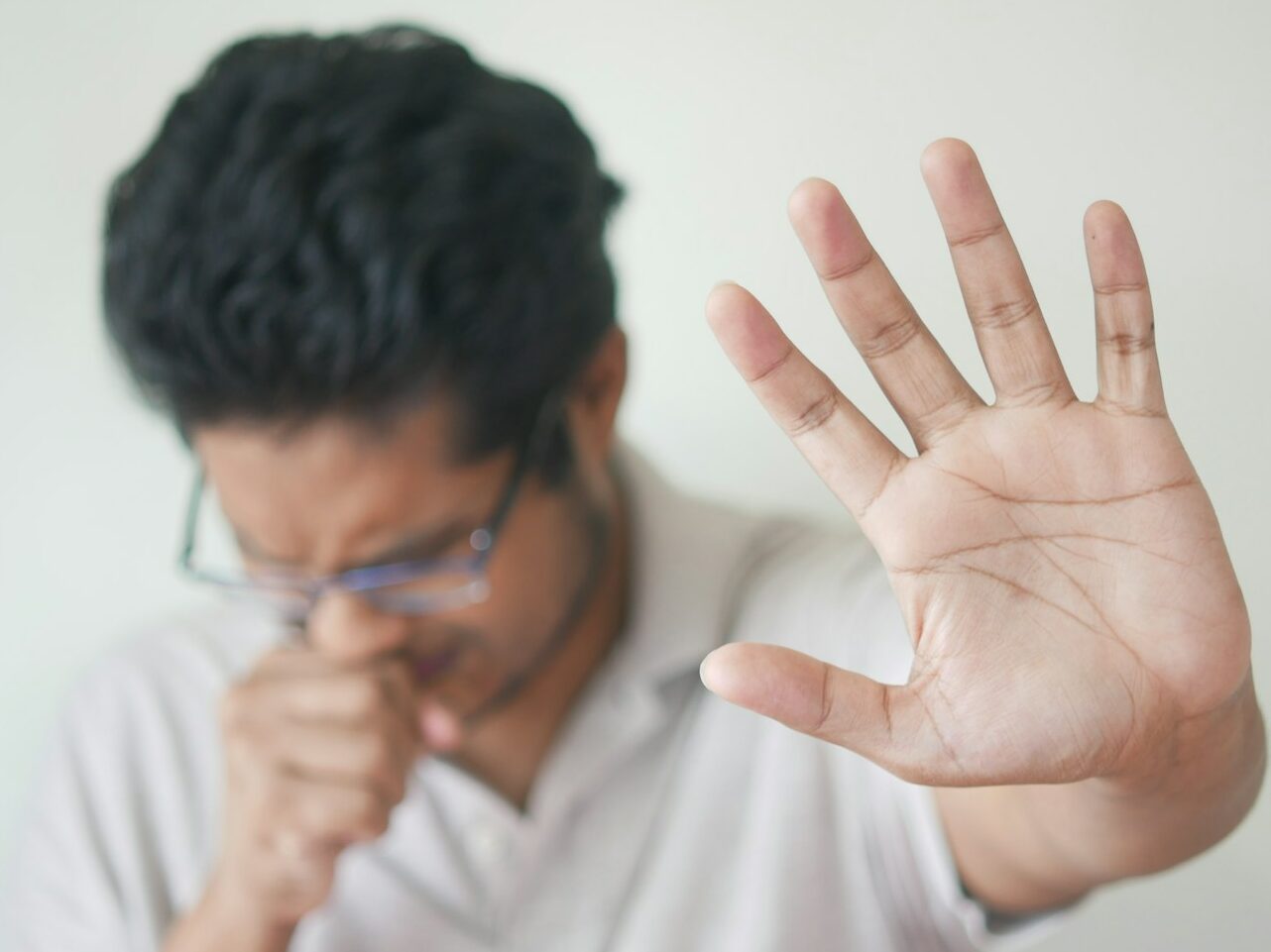 a man holding his hand up in front of his face