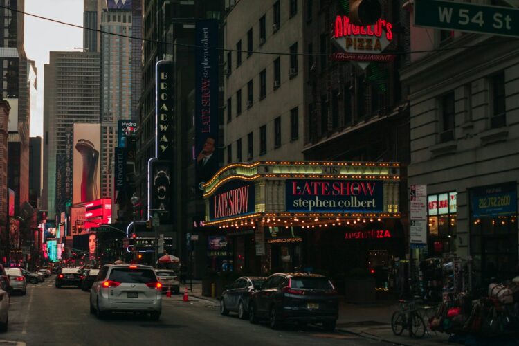 a city street filled with lots of traffic next to tall buildings