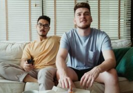 Men Sitting on a Couch while Seriously Looking at Something