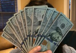 person holding fan of us dollar bill