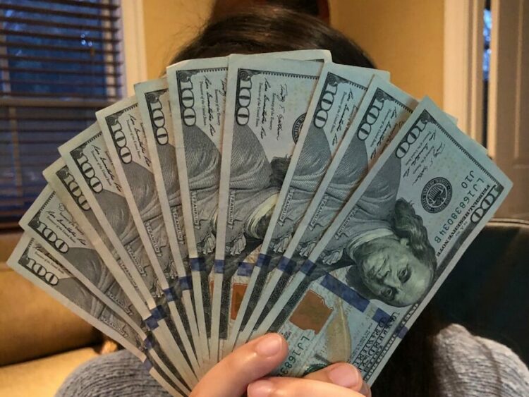 person holding fan of us dollar bill