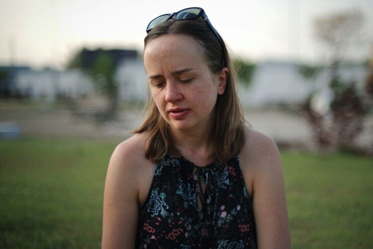 woman in halter top with sunglasses on head