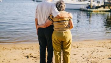 Senior couple embracing on a sunny beach. Perfect for travel and lifestyle themes.