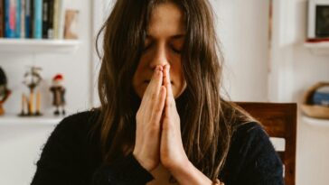 Woman practicing meditation indoors, highlighting calmness and mindfulness.