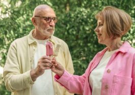 Happy senior couple sharing ice cream in a park, capturing love and togetherness.
