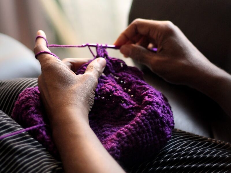 woman sewing purple textile