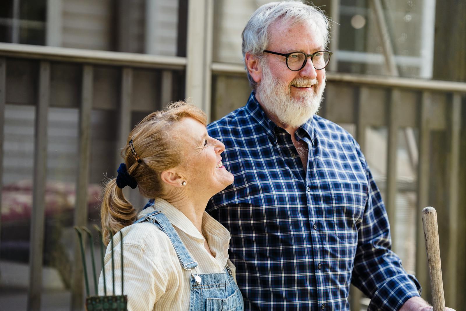 Senior couple enjoying gardening together on a sunny day, embodying a joyful rural lifestyle.
