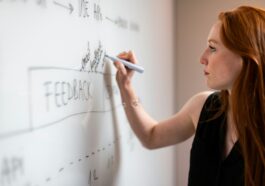 woman in black shirt holding white smartphone