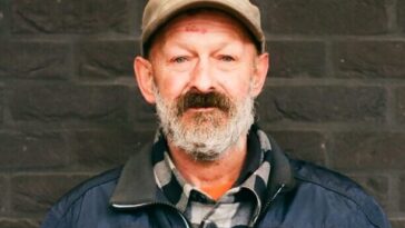 man in blue zip up jacket and brown hat