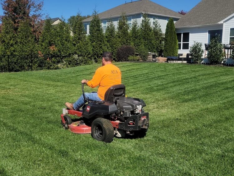 A man riding on the back of a lawn mower