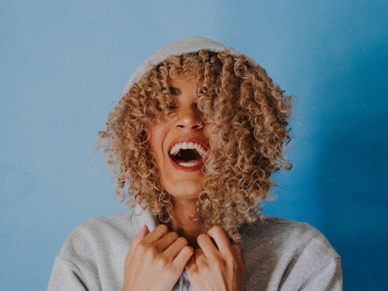smiling woman wearing gray hoodie