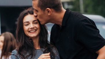 Smiling couple sharing an affectionate moment outdoors.
