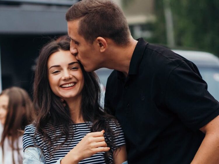 Smiling couple sharing an affectionate moment outdoors.