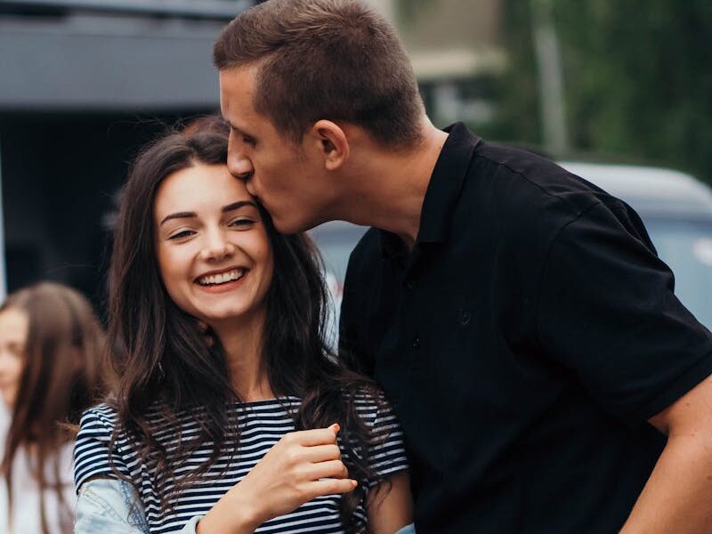 Smiling couple sharing an affectionate moment outdoors.