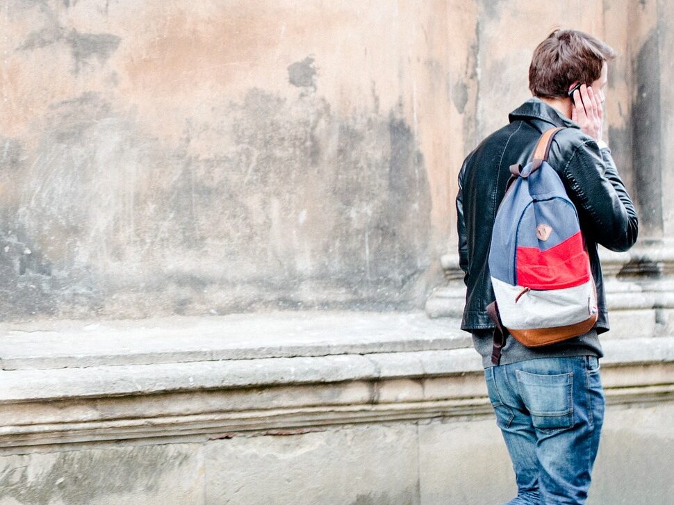 people, man, guy, walking, travel, phone, talking, backpack, outside, street, talking, backpack, backpack, backpack, backpack, backpack
