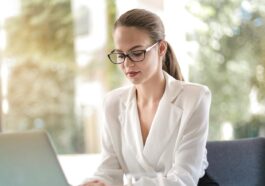 Confident businesswoman using a laptop at her desk, focused on her work.