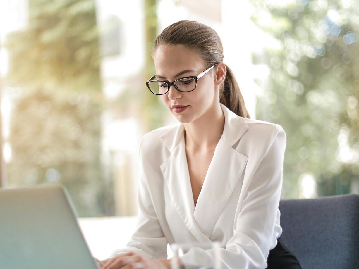 Confident businesswoman using a laptop at her desk, focused on her work.
