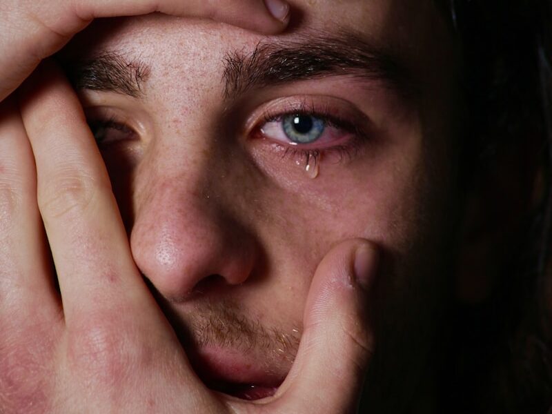 a man holding his hands to his face