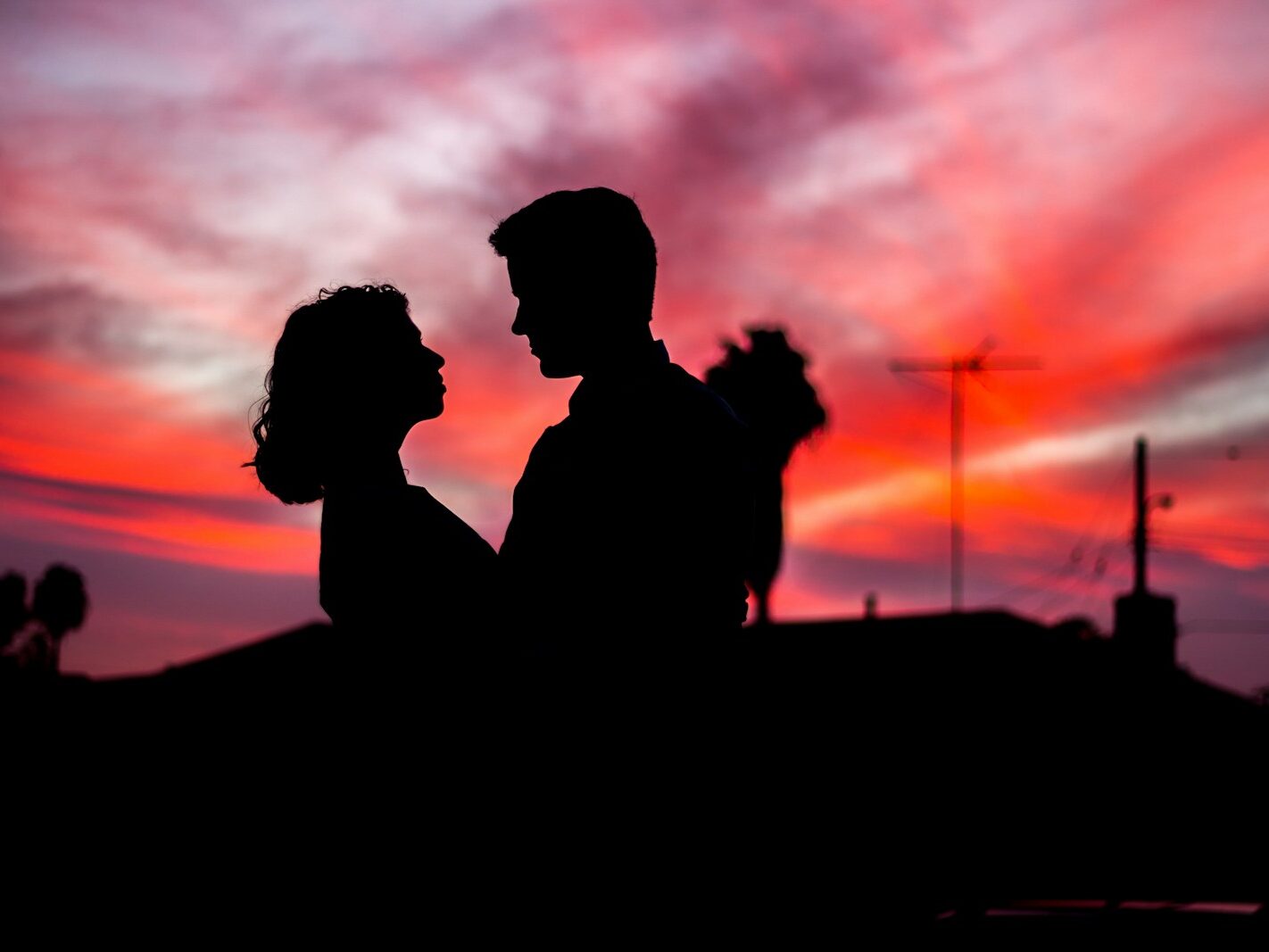 silhouette of man and woman facing each other during golden hour