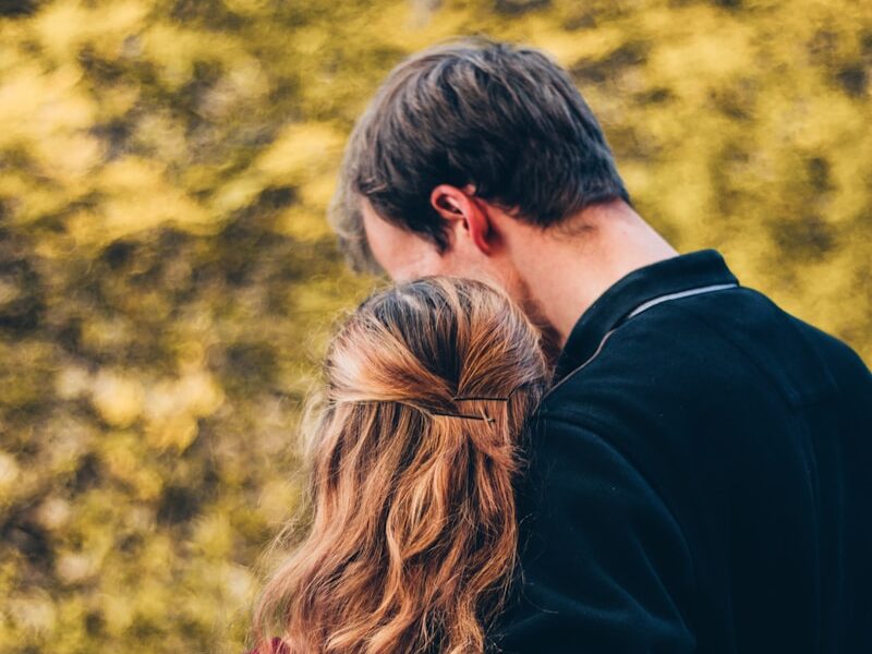 woman and man standing beside tree at daytime